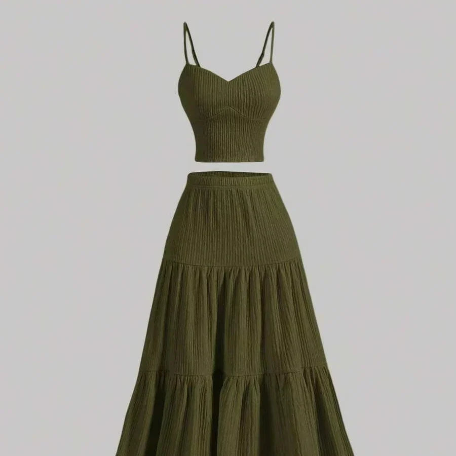 An olive green two-piece set featuring a ribbed knit crop top with spaghetti straps and a matching tiered maxi skirt, shown against a solid light gray background.
