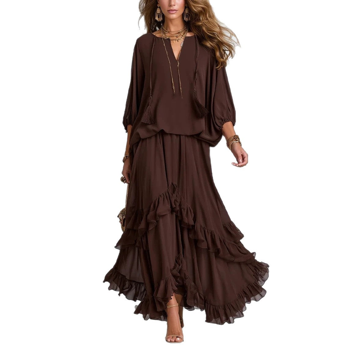 A woman modeling a dark brown bohemian-style two-piece set featuring a loose long-sleeve top and a tiered ruffled maxi skirt, shown against a plain white background.