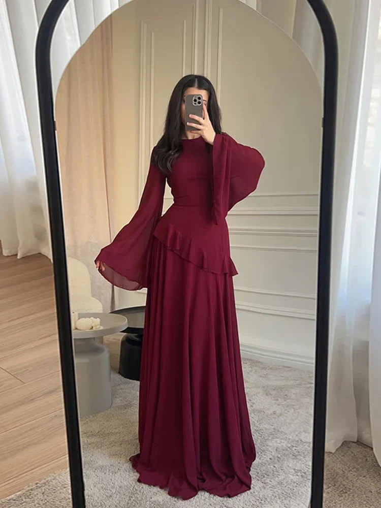 Person wearing a burgundy dress standing in front of a mirror.