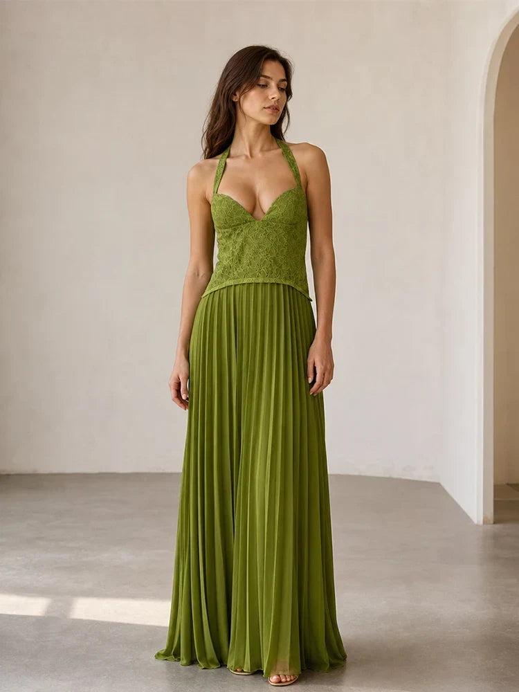 Woman wearing a green dress standing in a minimalistic room.