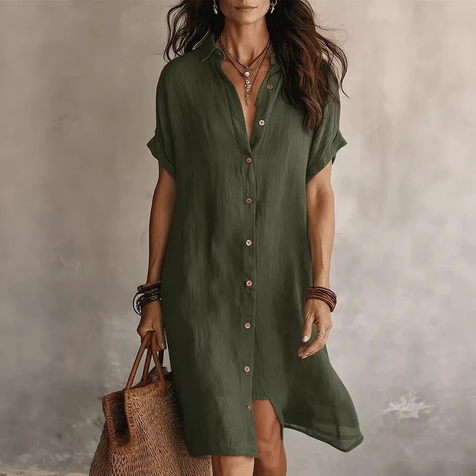 Woman wearing a green dress holding a woven bag against a neutral background