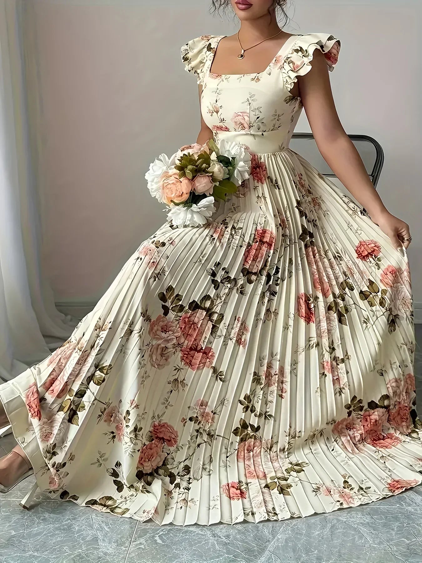 Woman wearing a floral dress holding a bouquet indoors.