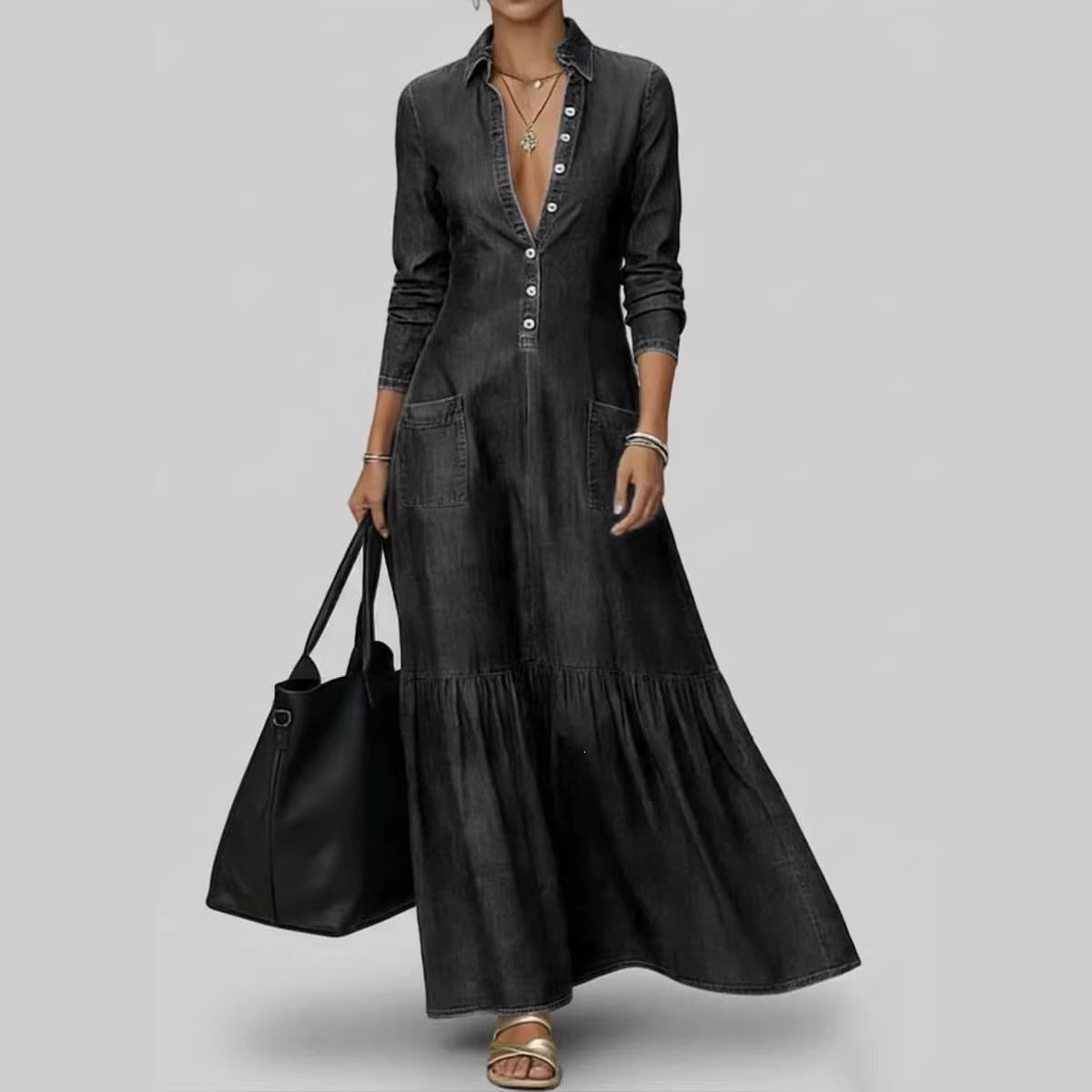 Woman wearing a long black dress holding a black bag on a gray background