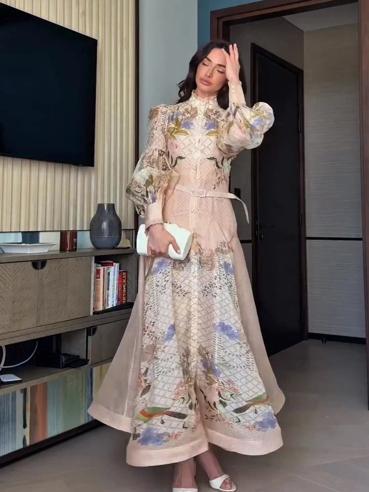 Woman in a floral dress standing in a room with a television and bookshelf.