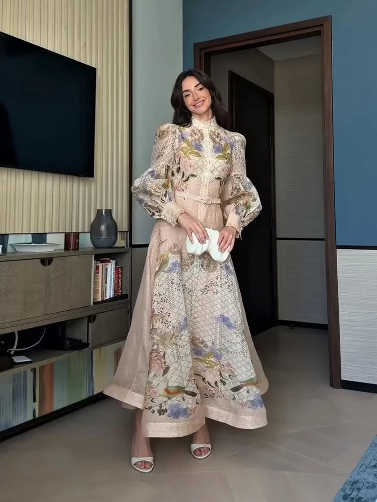 Woman in a floral dress standing in a room with a television and books.