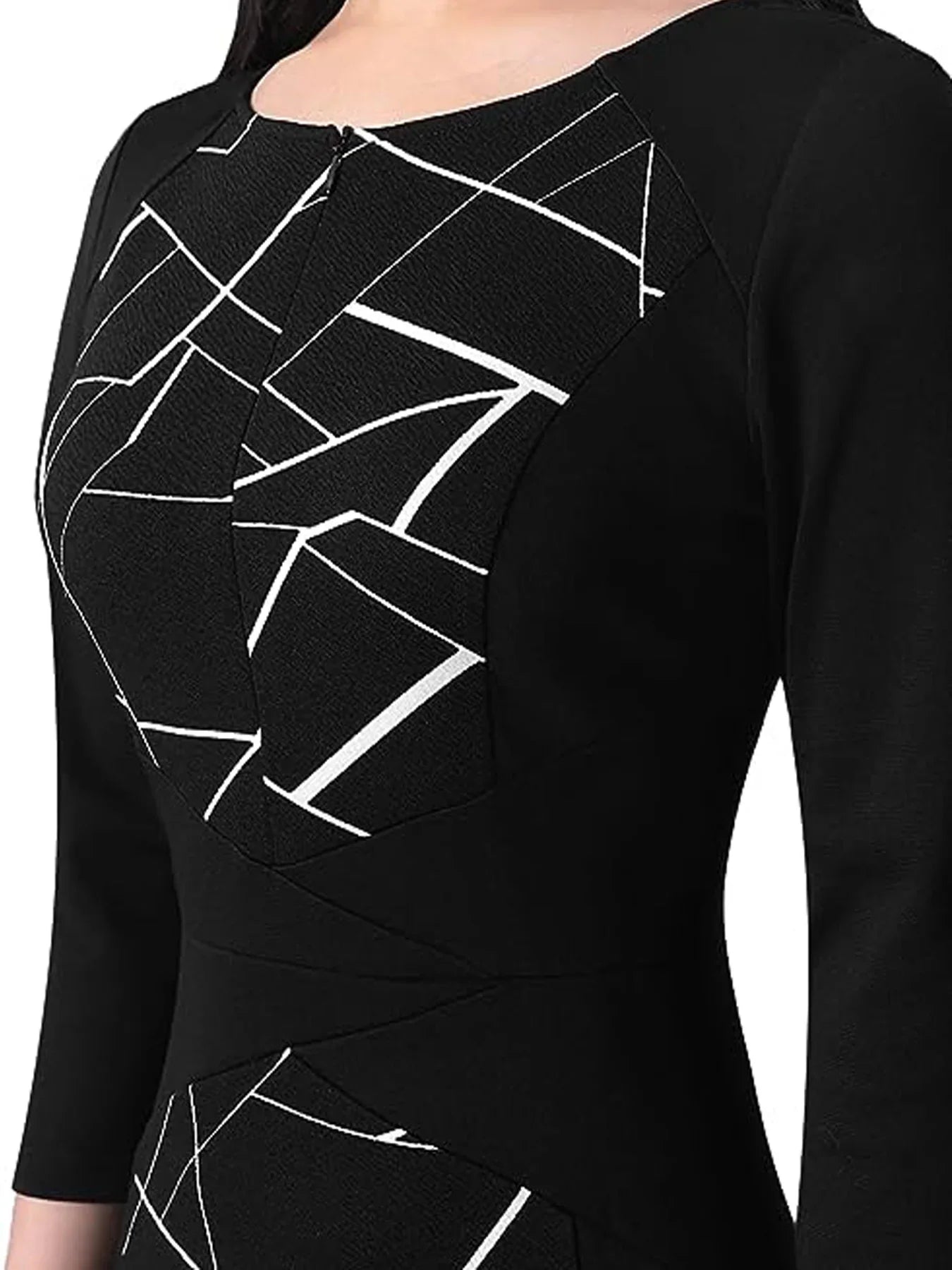A close-up of a black long-sleeve dress featuring a white geometric line pattern across the bodice and lower skirt, shown on a model against a white background.