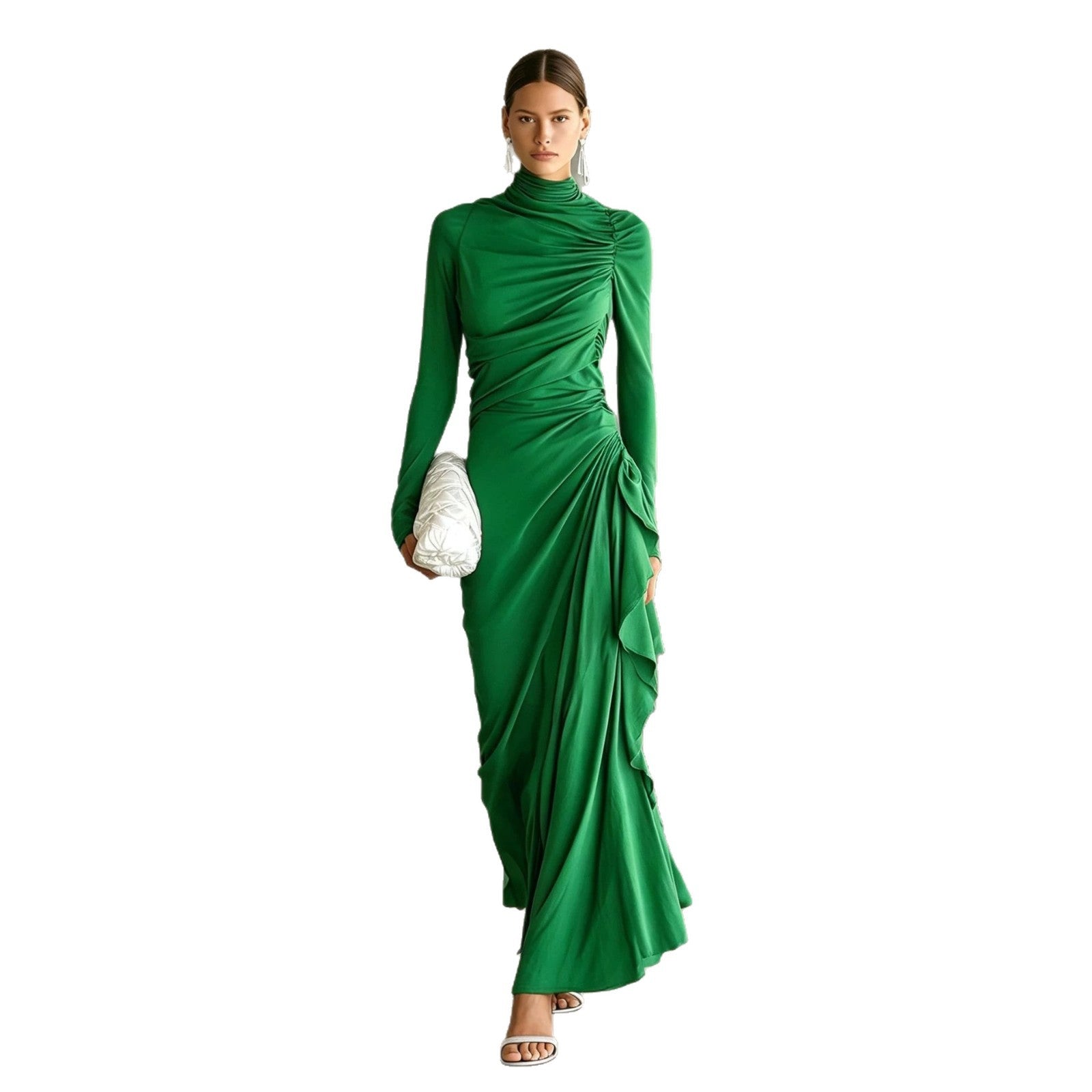 A woman modeling a long-sleeved, high-neck emerald green dress with dramatic draped ruching and a gathered waist, holding a textured white clutch against a solid white background.