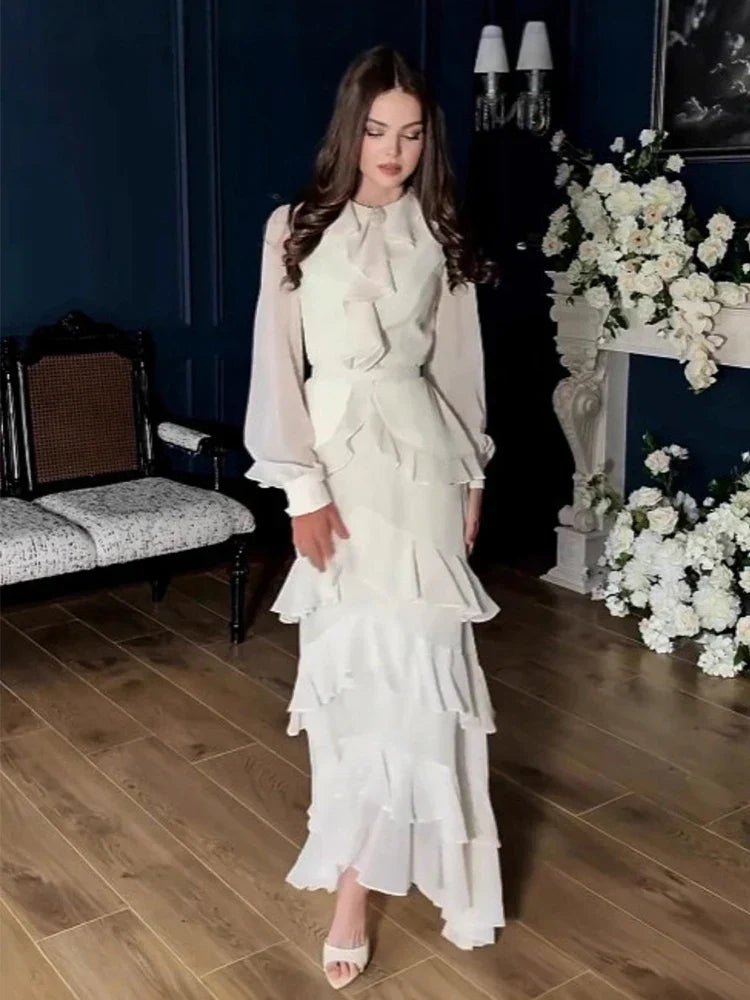 Woman in a white dress standing in a room with floral decorations