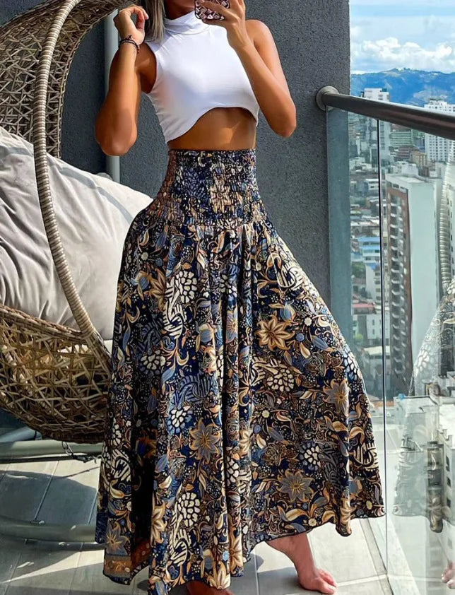 Woman wearing a white top and floral skirt on a balcony with cityscape view