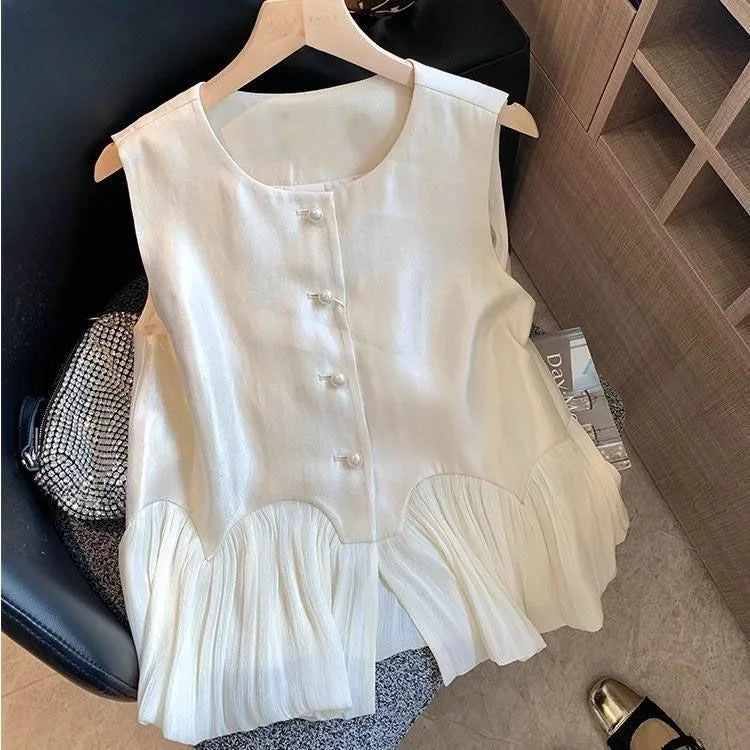 White sleeveless top on a hanger with a blurred background