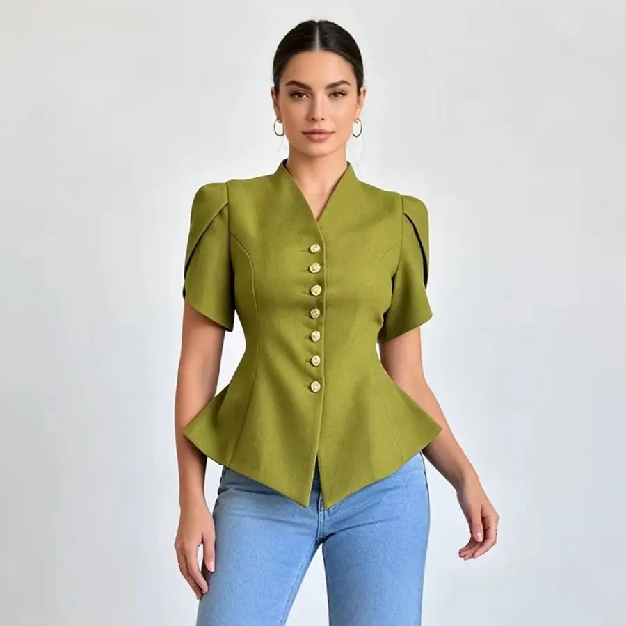 A woman modeling a structured olive green short-sleeve blouse with a V-neck, structured shoulders, and a row of gold buttons down the front, paired with light blue jeans against a light gray studio background.