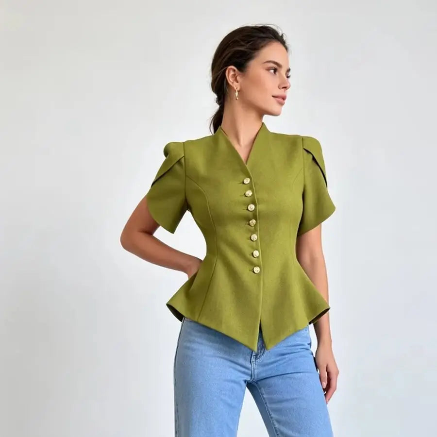 A woman modeling a short-sleeve olive green peplum-style blouse with decorative gold buttons down the front and structured shoulders, paired with light blue jeans against a plain light gray studio background.