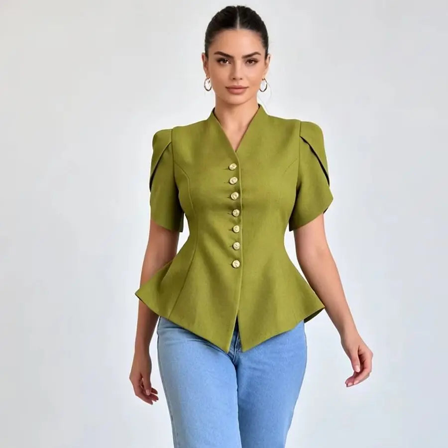 A woman modeling a short-sleeve olive green peplum blouse with gold buttons down the front and black piping details on the shoulders, paired with light blue jeans against a light gray background.