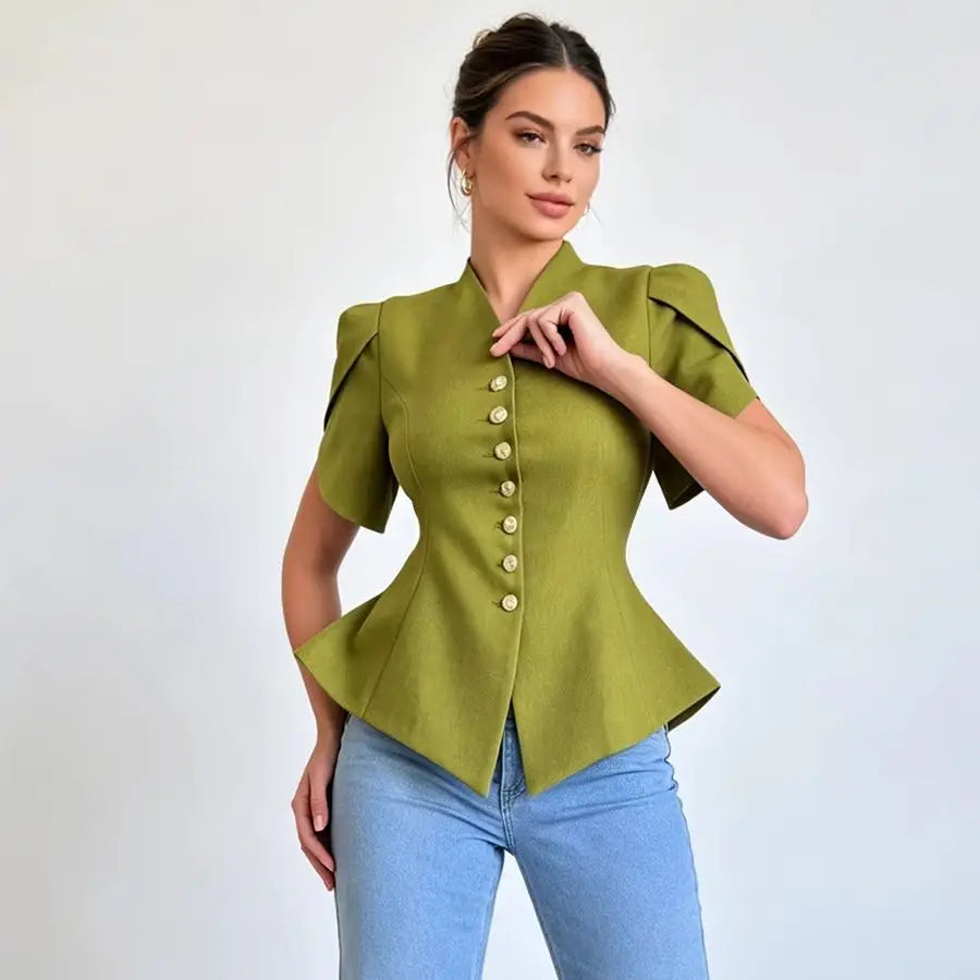 A woman modeling a short-sleeve olive green peplum blouse with structured shoulders and a central row of gold buttons, paired with light blue jeans against a plain light gray background.